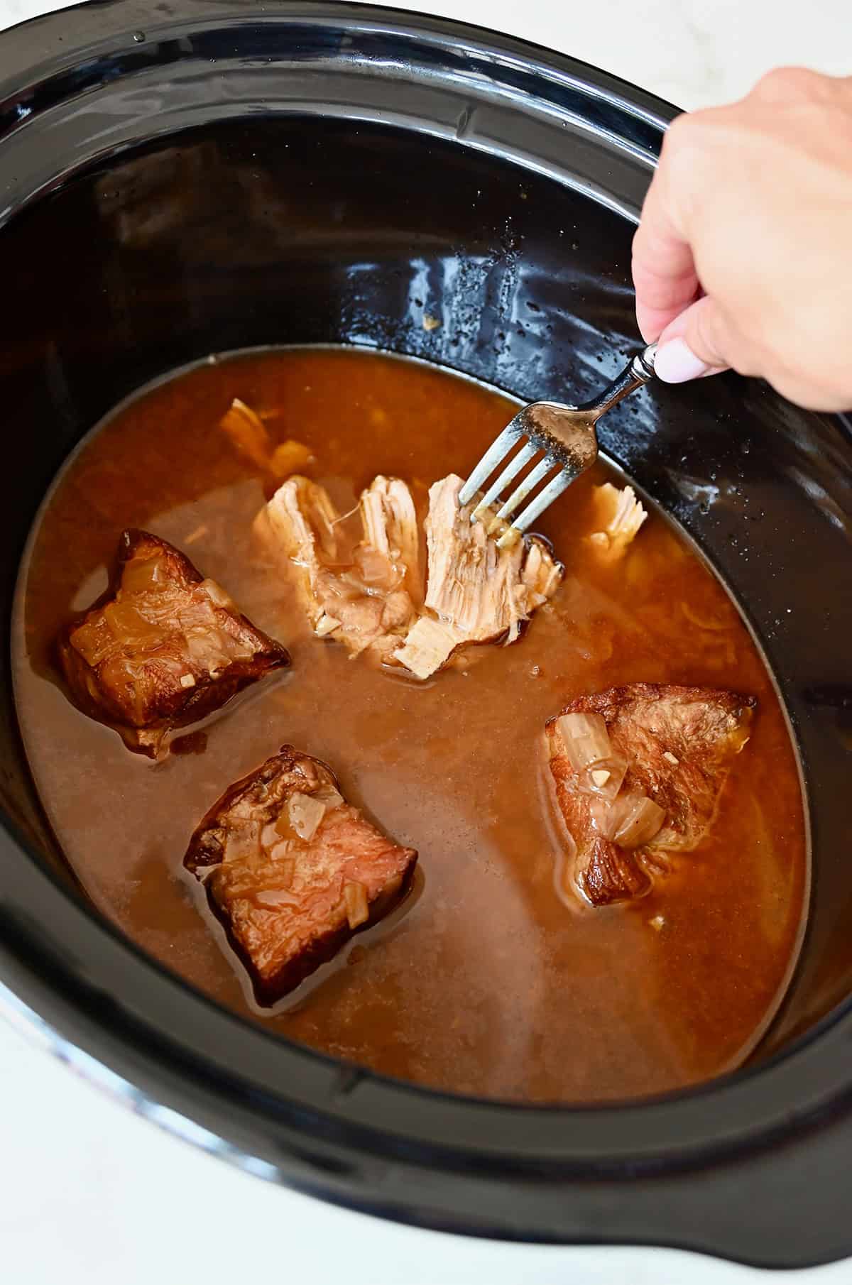 Mexican pulled pork that's fork-tender after slow cooking in a slow cooker.