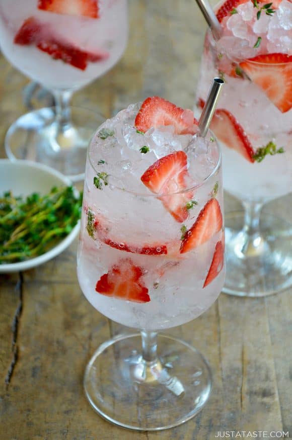 A Sparkling Strawberry Cocktail with fresh strawberries and thyme