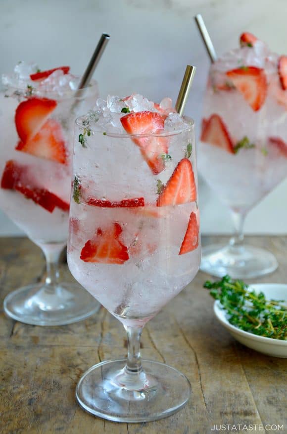 A clear glass containing sliced strawberries and crushed ice