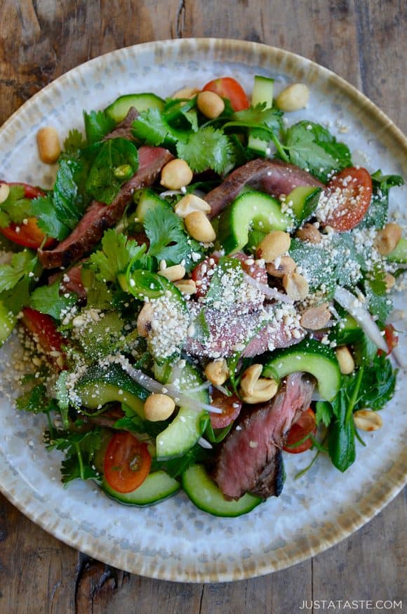 Top down view of plate containing Thai beef salad garnished with chopped peanuts and cheese 