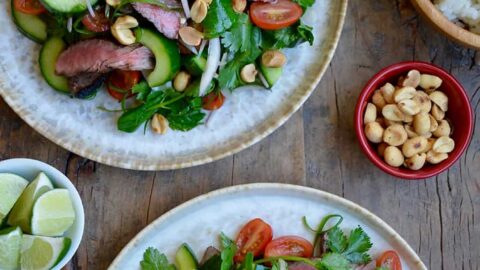 Two plates containing easy Thai Beef Salad with Lime Dressing garnished with peanuts