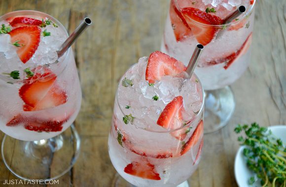 Three glasses filled with sparkling soda and sliced strawberries