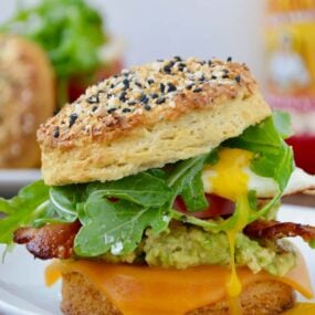 The Ultimate Biscuit Breakfast Sandwich with arugula, avocado, bacon and tomato