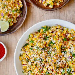 The best Elote Corn Salad topped with fresh herbs and Cotija cheese