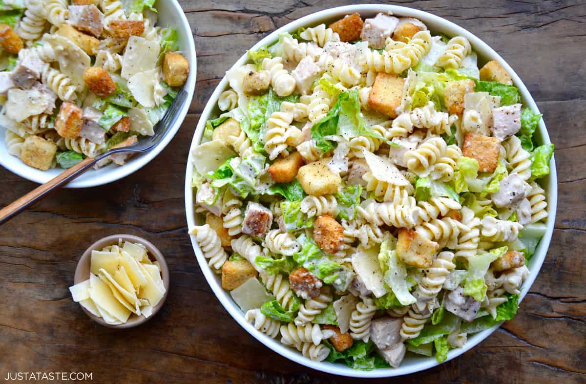 A large bowl and a small bowl containing Chicken Caesar Pasta Salad with croutons.