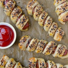 Everything Puff Pastry Pigs In a Blanket on parchment paper
