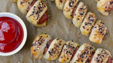 Everything Puff Pastry Pigs In a Blanket on parchment paper