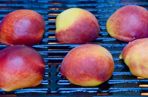 Peach halves being grilled