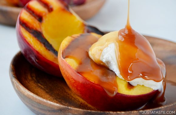 Close-up view of easy grilled peaches topped with ice cream and boozy caramel sauce