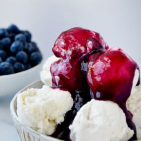 Bowl containing vanilla ice cream topped with 10-Minute Blueberry Sauce