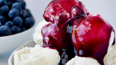 Bowl containing vanilla ice cream topped with 10-Minute Blueberry Sauce