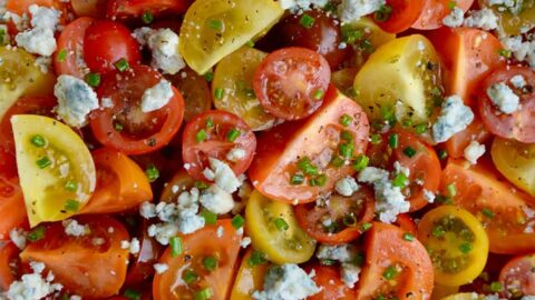 Top down view of Steakhouse Tomato Salad with Blue Cheese and chives