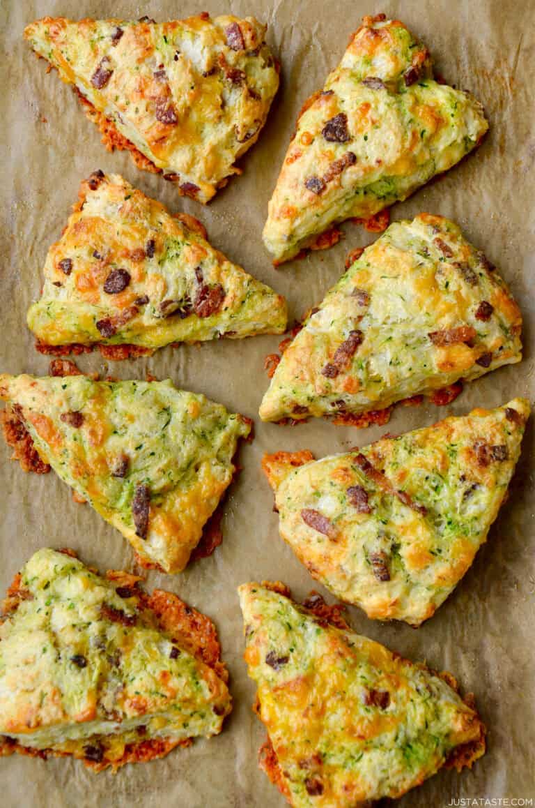 Eight savory Zucchini Bacon Cheddar Scones on brown parchment paper.