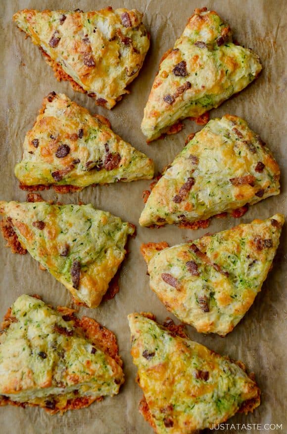 Top down view of eight savory Zucchini Bacon Cheddar Scones on brown parchment paper