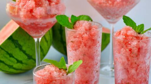 Various sized cocktail glasses filled with Boozy Watermelon Granita and fresh mint
