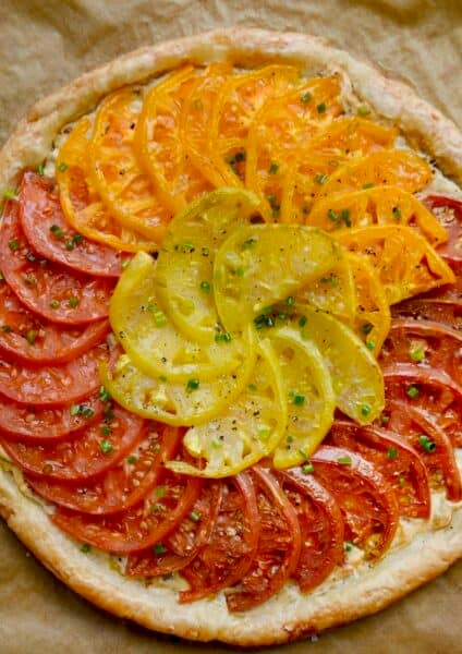 An heirloom tomato tart made with puff pastry and a cheesy caramelized onion spread.