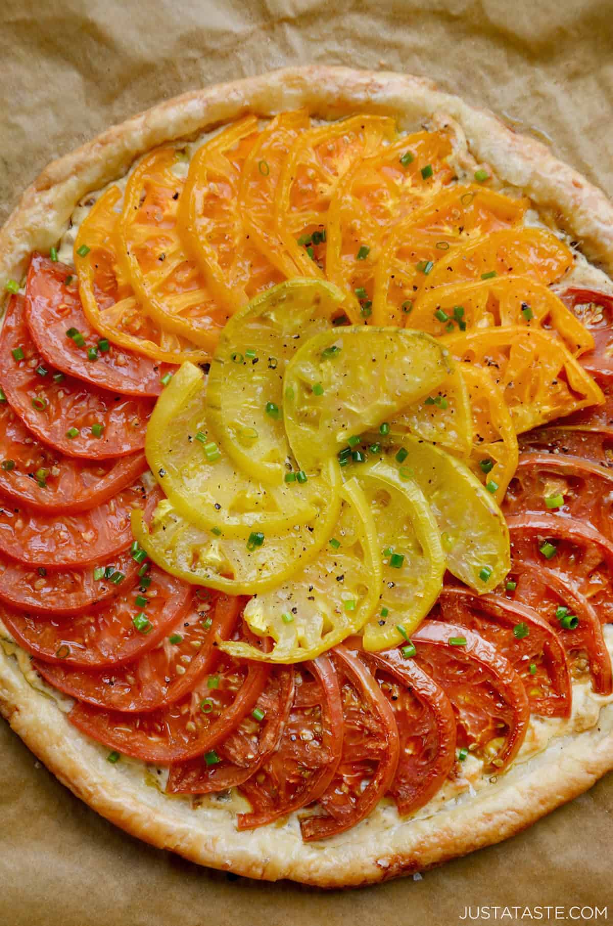 An heirloom tomato tart made with puff pastry and a cheesy caramelized onion spread.