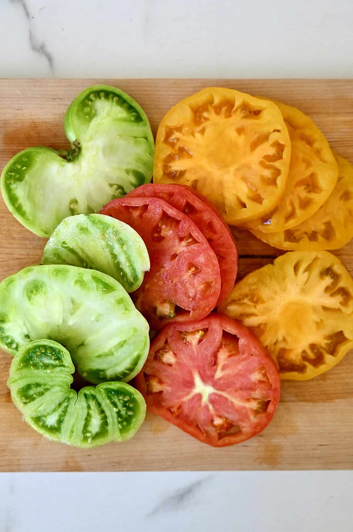Sliced heirloom tomatoes on a cutting board.