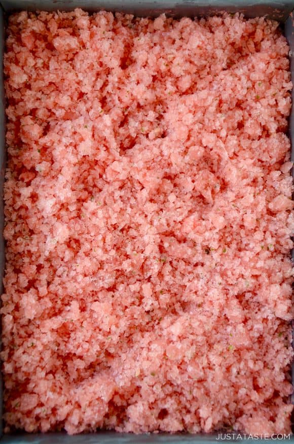 Top down view of metal baking sheet containing watermelon granita