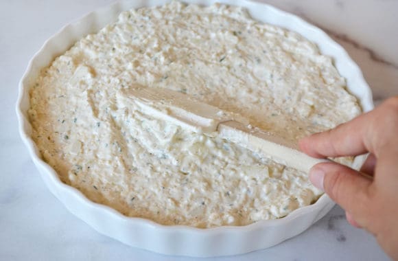 A white baking dish with Crack Dip and a spatula