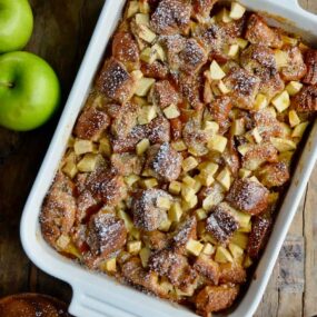 A white serving dish containing freshly baked Caramel Apple Bread Pudding