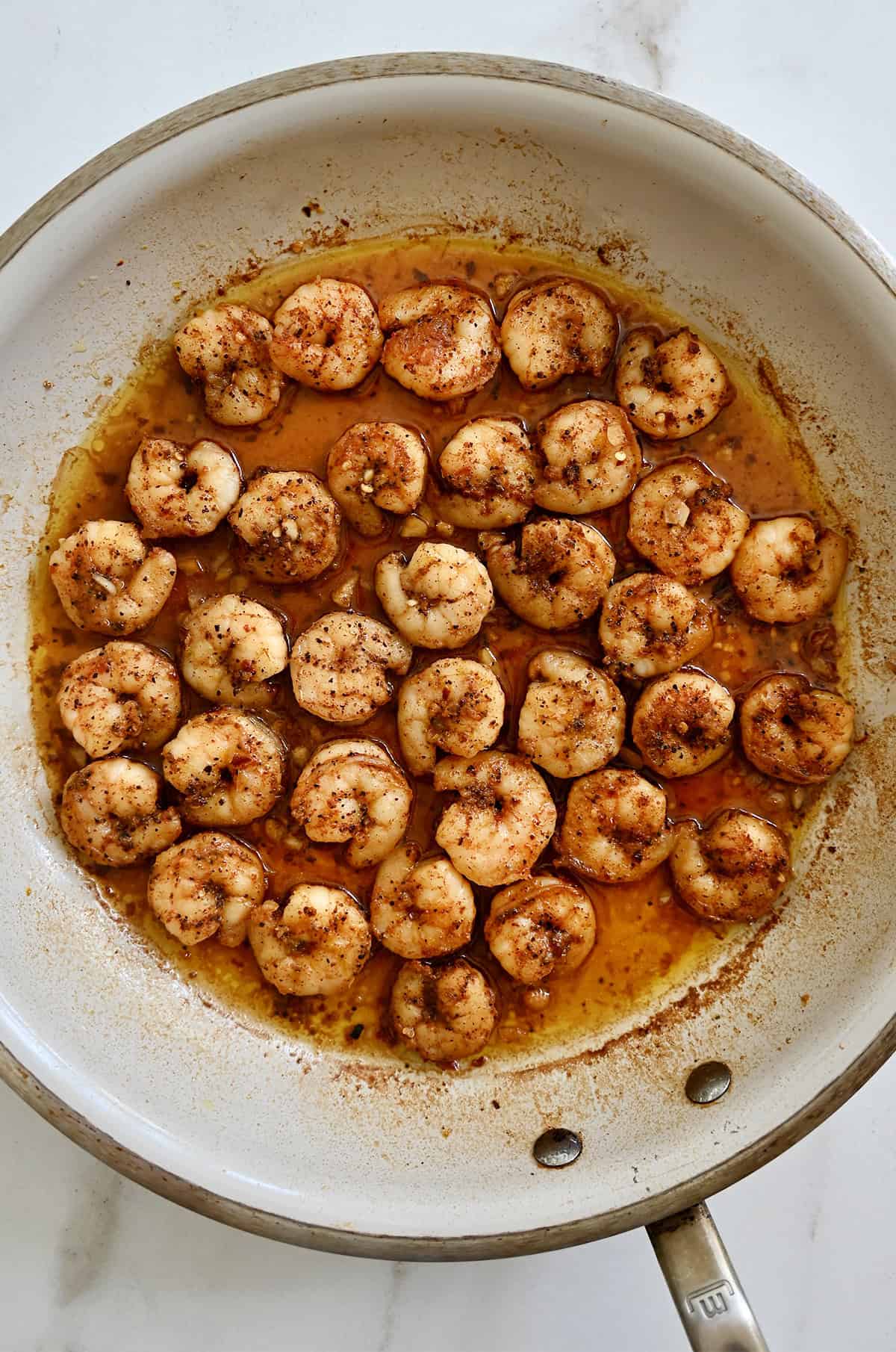Cooked spicy shrimp in a large skillet.