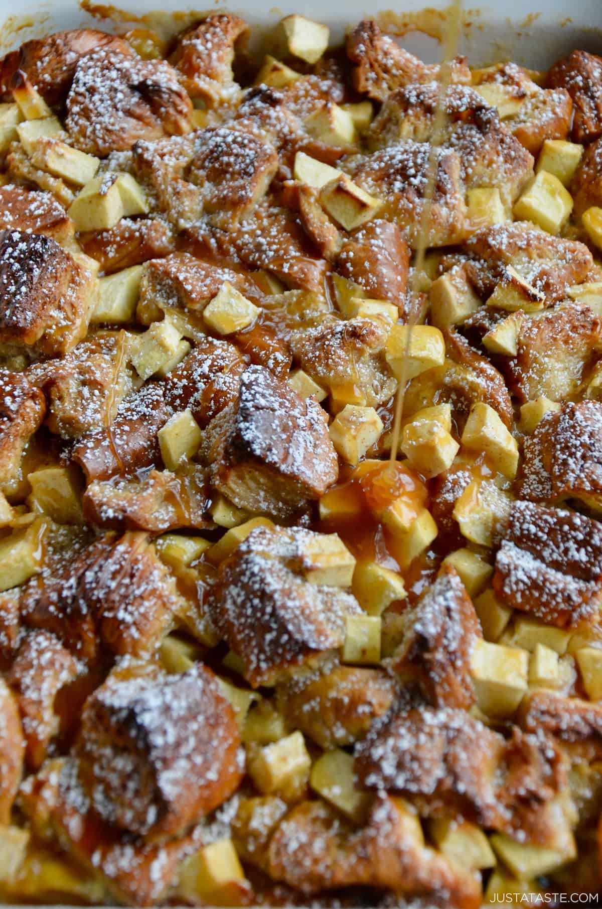 Caramel sauce is being drizzled atop freshly baked apple pudding.