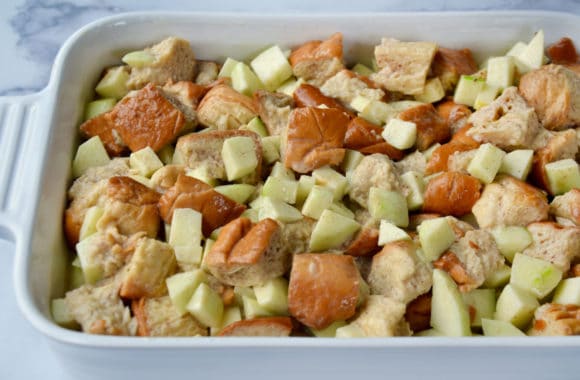 White baking dish containing unbaked apple bread pudding