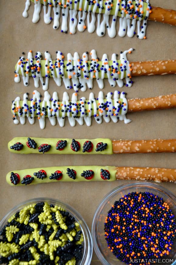 Brown parchment paper topped with bowls of Halloween sprinkles and pretzel rods