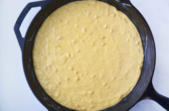 Cast iron skillet containing batter