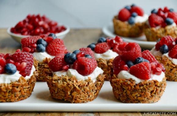 Easy Muffin Tin Granola Cups topped with yogurt and fresh berries on white serving plate