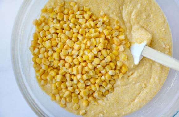 Glass bowl containing batter with corn kernels