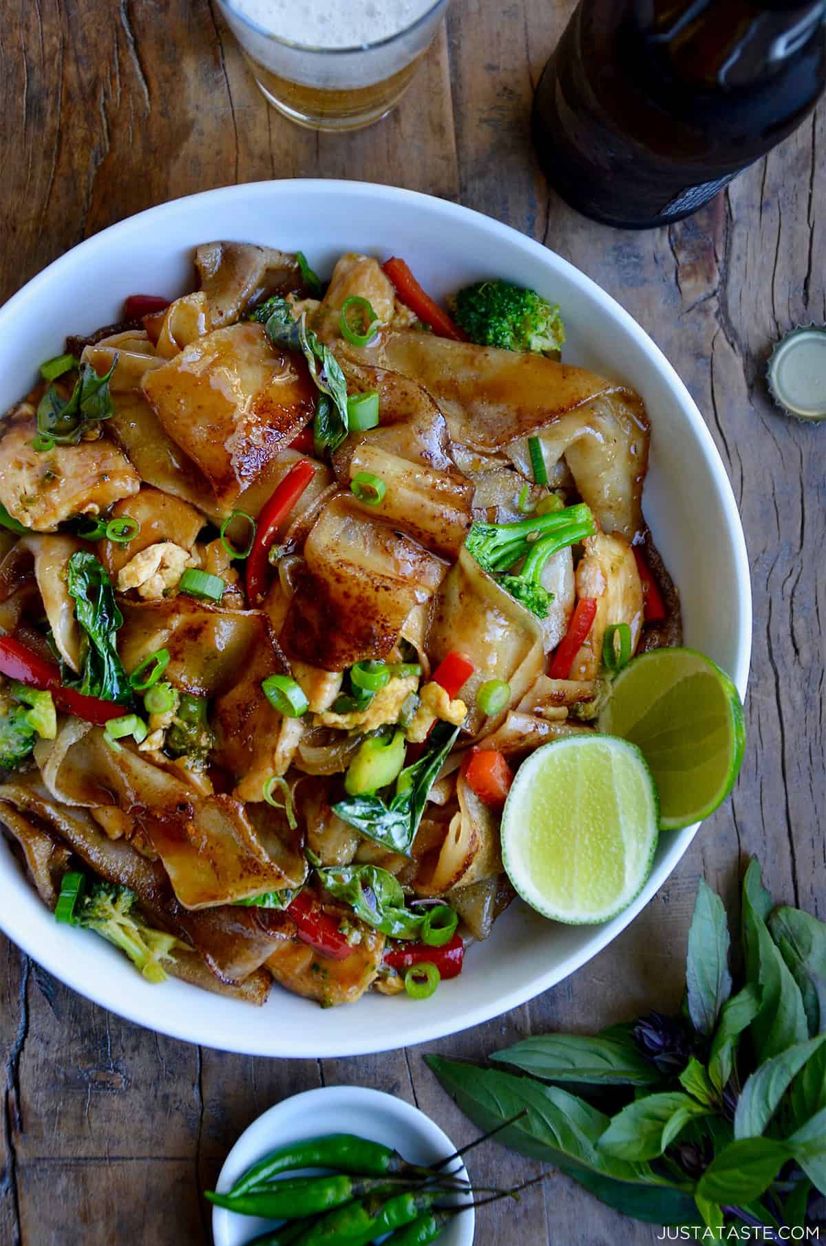 Drunken noodles with wide rice noodles, chicken, veggies and Thai basil in a bowl.