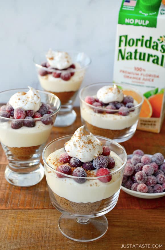 Glass parfait glasses filled with cheese and a carton of orange juice in the background