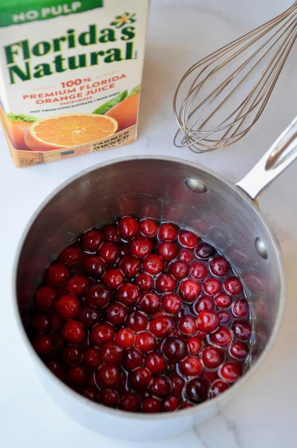 A saucepot filled with cranberries and orange juice