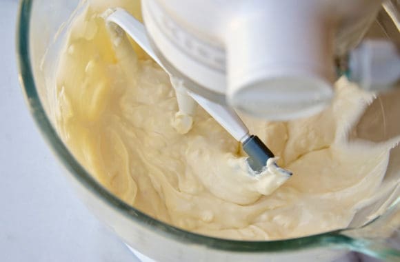 A clear stand mixer bowl with cheesecake filling inside