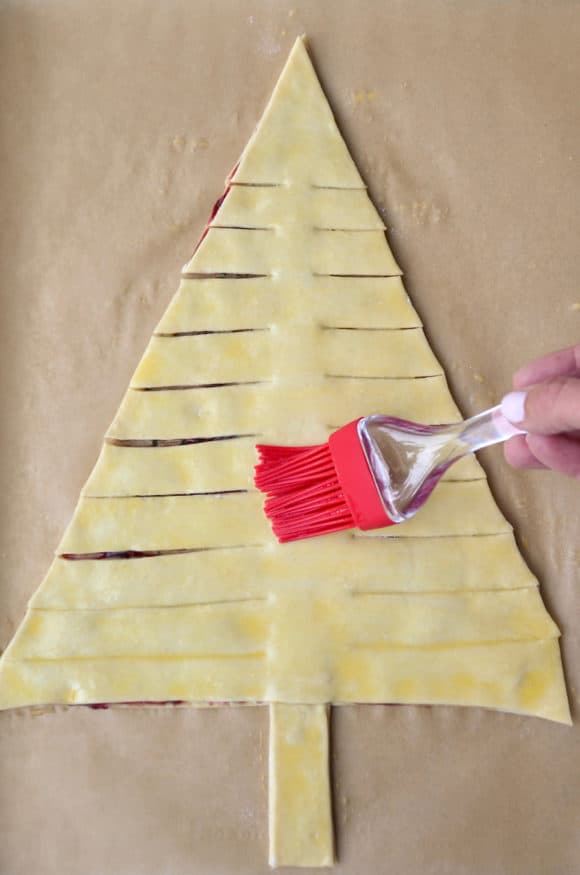 Brushing egg wash atop holiday puff pastry appetizer