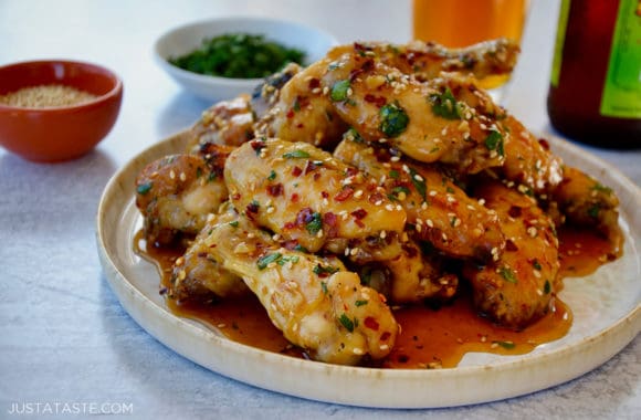 A plate containing chicken wings with cilantro and sesame seeds