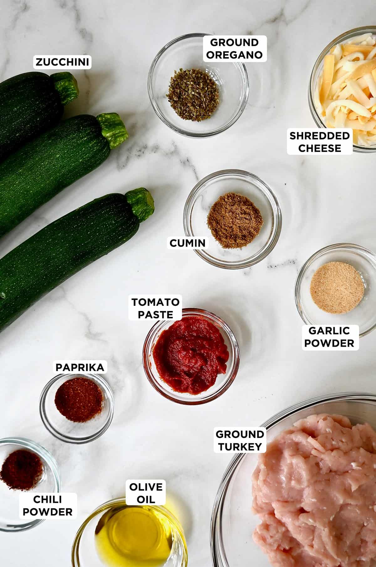 Ingredients to make zucchini boats, including medium-sized zucchini, ground meat, taco seasoning and shredded Mexican cheese.