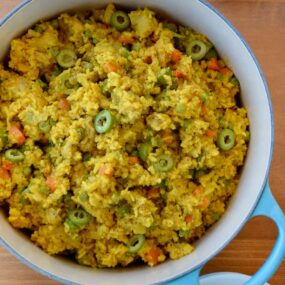 Dutch oven containing Chicken and Yellow Rice with sliced green olives