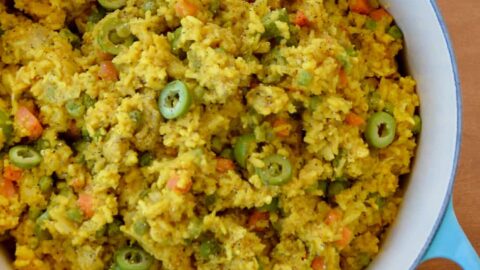 Dutch oven containing Chicken and Yellow Rice with sliced green olives