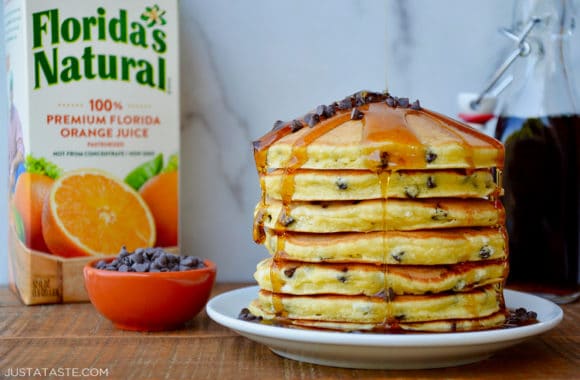 A plate of pancakes topped with chocolate chips and syrup