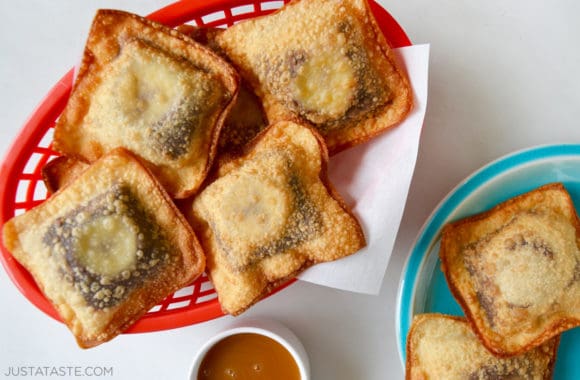 Banana Chocolate Wonton Poppers in a red food basket next to ramekin with caramel sauce