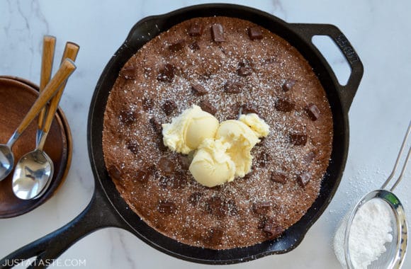 A cast-iron skillet brownie topped with vanilla ice cream