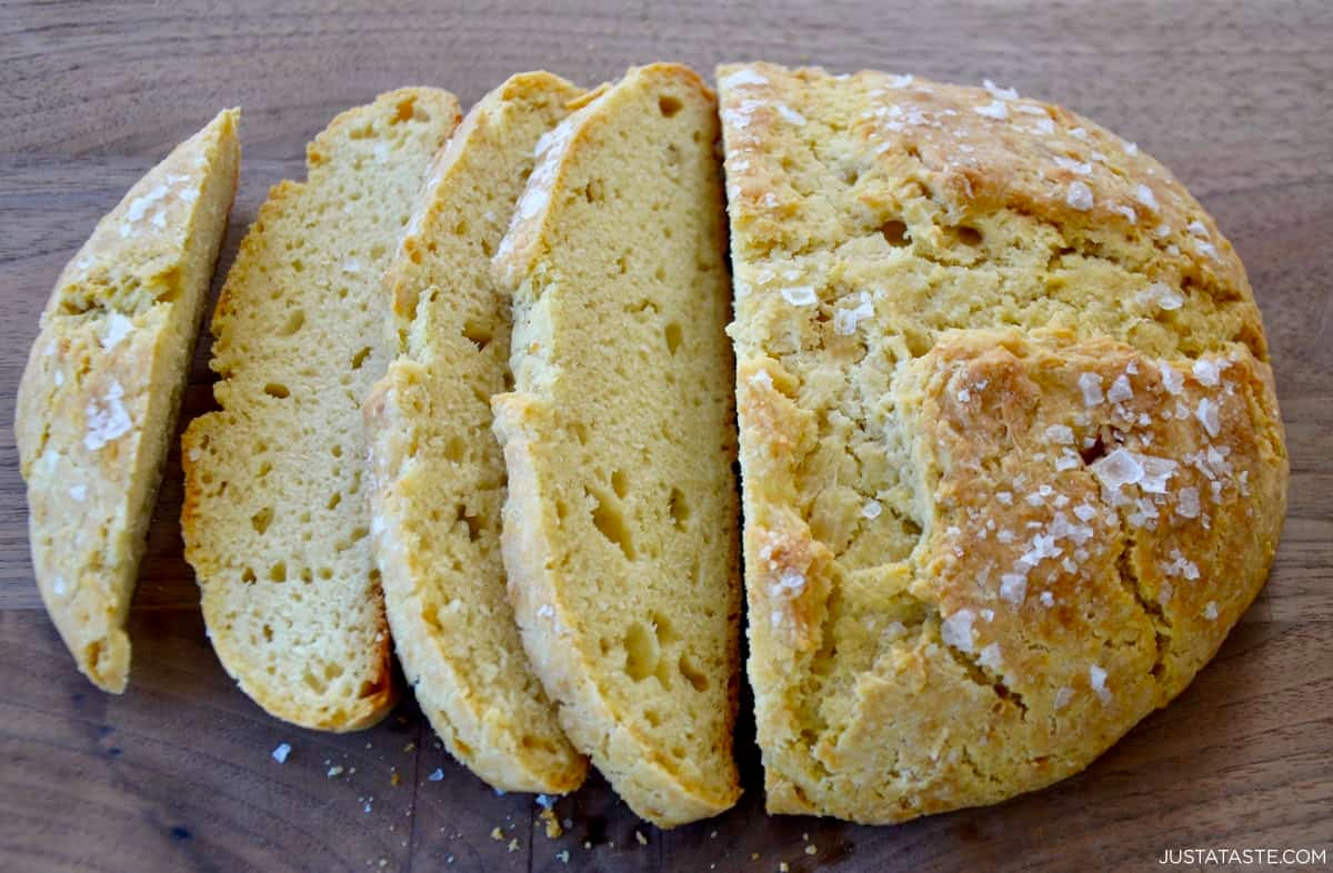 Freshly baked loaf of homemade bread without yeast, topped with large-flake sea salt, cut into slices.
