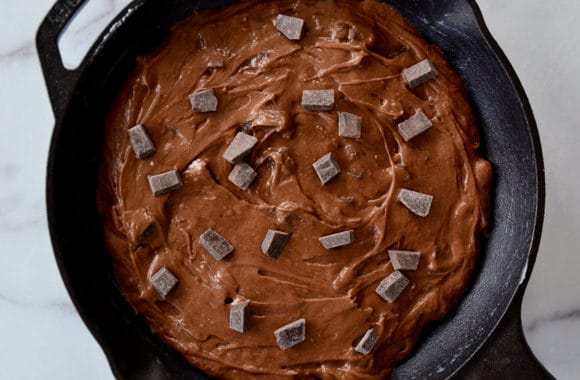 A cast-iron skillet filled with brownie batter