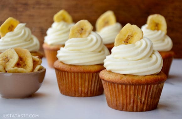 Banana Cupcakes topped with piped cream cheese frosting and a banana chip