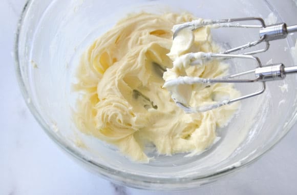 A glass bowl with cream cheese frosting
