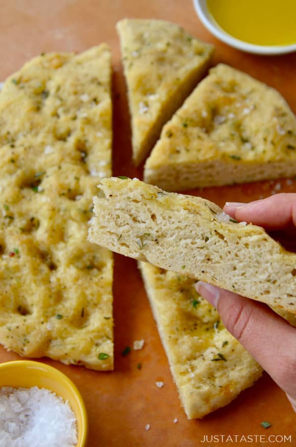 Hand holding a slice of no-yeast focaccia bread 