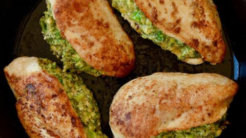A cast-iron skilled with four stuffed chicken breasts